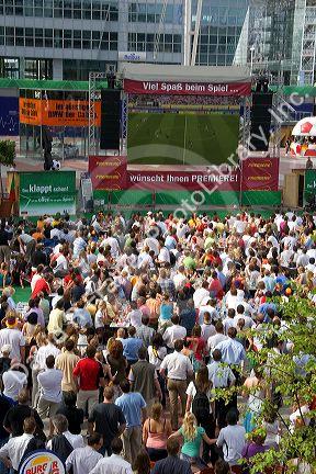 A crowd outdoors at the Munich airport watch a 2006 World Cup match on big screen televisions, Germany.