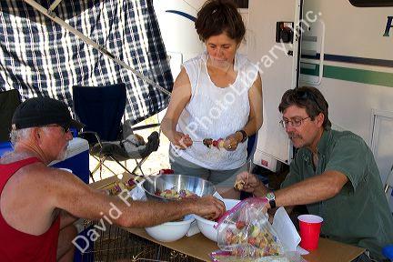 Campers preparing shish kabob meal.