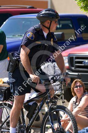 Police officer on a bicycle at a small town Fourth of July parade in Cascade, Idaho.