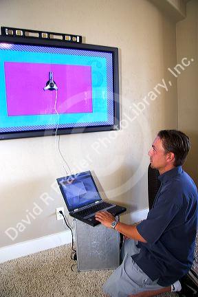 Technician installs and calibrates flat screen plasma television.