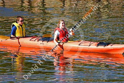 People sea kayaking in the Bay of Fundy at St. Martins, New Brunswick, Canada.
