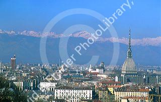 The Mole tower dominates the skyline of Turin, Italy with the Dolomite Mountains in the background.