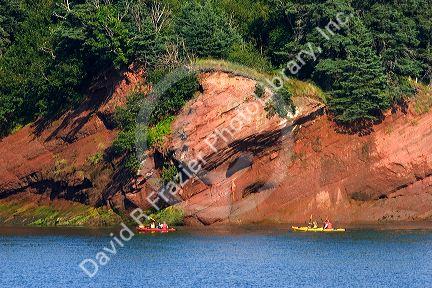 People sea kayaking in the Bay of Fundy at St. Martins, New Brunswick, Canada.