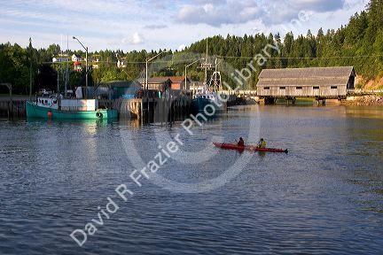 People sea kayaking at high tide in the Bay of Fundy at St. Martins, New Brunswick, Canada.