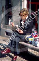 Woman reading Italian newspaper in Turin, Italy.