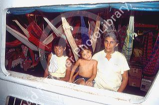 Mother, daughter, and granddaughter on riverboat with hammocks in Manaus Brazil.  Brazillian family.