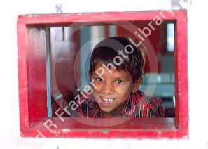 Native boy looking out the window of a riverboat on the Amazon River at Manaus Brazil.