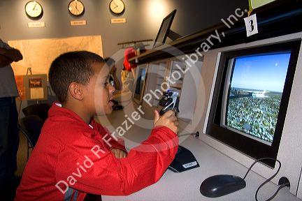 An african american boy using a flight training computer at the McDonnell Planetarium in St. Louis, Missouri.