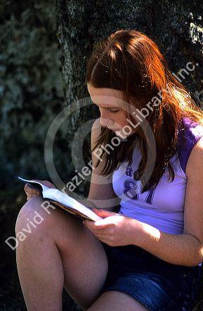 A teenage girl reading a book. MR