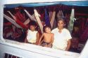 Mother, daughter, and granddaughter on riverboat with hammocks in Manaus Brazil.  Brazillian family.