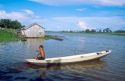 Native boy paddling his canoe on an arm of the Amazon River near Manaus Brazil.