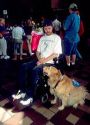 Hanicapped man in a wheelchair uses helper dog to complete tasks he can not do himself.