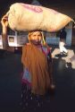 Indian woman carrying a bag on her head in India.