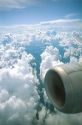 Passenger view of jet engine and clouds.