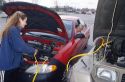 Students jump start a car which has a dead battery.
