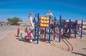 Elementary school students climbing on playground toys.