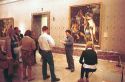 Interior of the Prado art museum showing paintings and visitors.