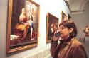 Female tourist listening to a translator at the Prado art museum in Madrid, Spain.