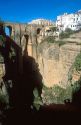 The gorge in Ronda, Spain with buildings on the edge and a view of the bridge.