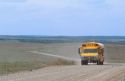 School bus traveling on a rural dirt road in Oklahoma.
