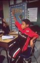 African American boy raising his hand in an Elementary school classroom. MR