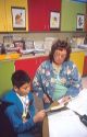 Elementary school teacher helping a male hispanic student in the classroom.  MR