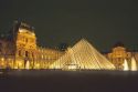 Glass pyramid entrance to the Louvre at night in Paris, France.