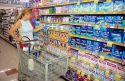 Woman shopping in the feminine hygene section of a grocery store.