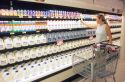 Woman shopping for milk in a grocery store.