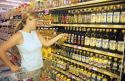 Woman shopping for olive oil in a grocery store.