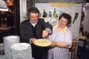 An Italian couple prepare a pasta dish at their restaurant in Italy.