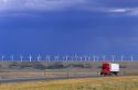 A truck traveling on the highway with a row of windmills in the background in Arlington, Wyoming.