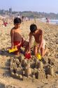 Young boys build a sandcastle on the beach in Renaca, Chile.