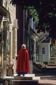 Woman wearing a red cape in front of a shop in colonial Williamsburg, Virginia.