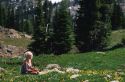 A woman sitting in an Idaho mountain meadow with flowers.