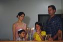 A jewish family lighting a menorah.  MR