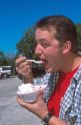 Man eating strawberry shortcake at Parkdale Farms in Plant City, Florida.