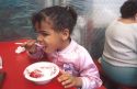 Young african american girl eating strawberry shortcake at Parkdale Farms in Plant City, Florida.