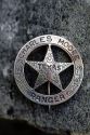 A distinctive circle and star Texas Ranger badge belonging to Charles Moore.