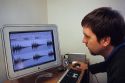 Sound engineer examines a spectrogram on a computer screen.