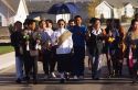 Laotian wedding procession in Boise, Idaho. The groom is escorted to the bride's house for the wedding ceremony by friends and relatives. Groom is dressed in traditional attire walking through a modern american suburban housing development.