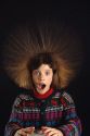 Girl with hair standing on end do to static electricity.