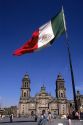 The national flag of mexico stands in front of the Catedrale Metropolitana in Mexico City, Mexico.