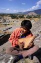 A young mexican man playing a native lyre harp at Teotihuacan archeological site in Mexico.