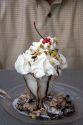 Chocolate sundae with whipped cream and cherry topping.