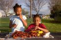 African american girls eating crawfish and corn on the cob in New Orleans, Louisiana.