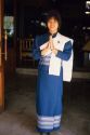A thai woman in traditional dress.  Clasped hands signify the traditional formal greeting.