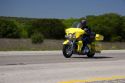 Morotcyclist on yellow road bike cruises Interstate 10 in West Texas.