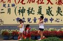 Children walk past a sign with Chinese characters in Taipei, Taiwan.