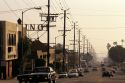 A Los Angeles street lined with cars and electric power lines, California.